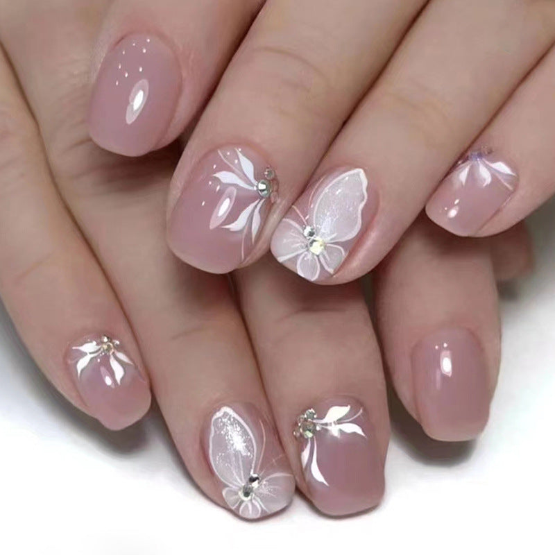 Elegant Butterfly Nail Art Design, Pink Base with White Floral Pattern, Crystal Rhinestone Accents, Press on Nails